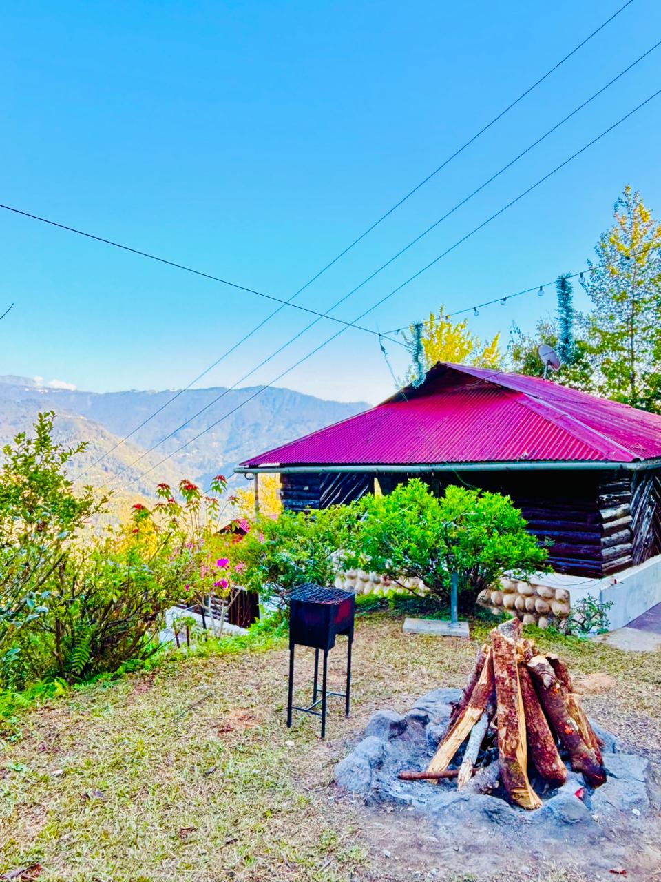 Bonfire pit and barbecue grill beside a cottage overlooking the valley
