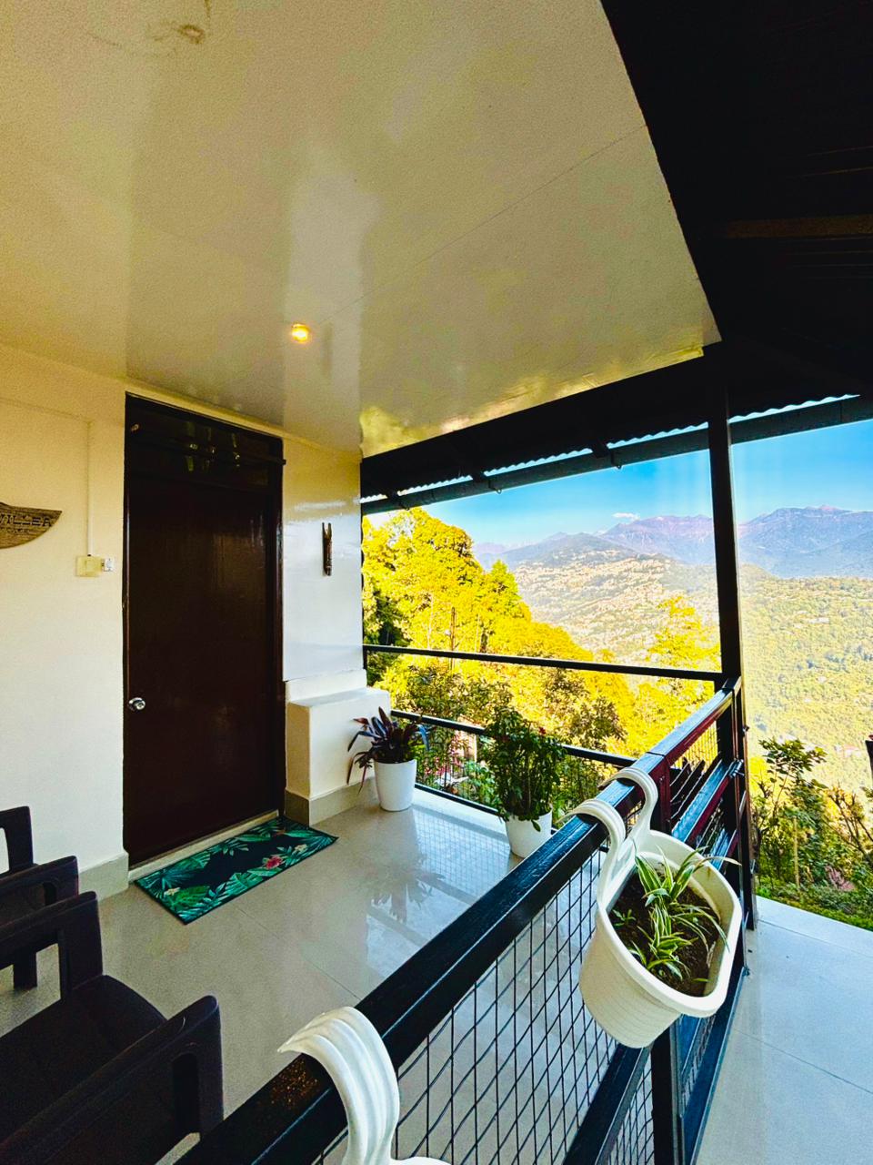 Cottage balcony looking out over forested slopes and mountain ranges