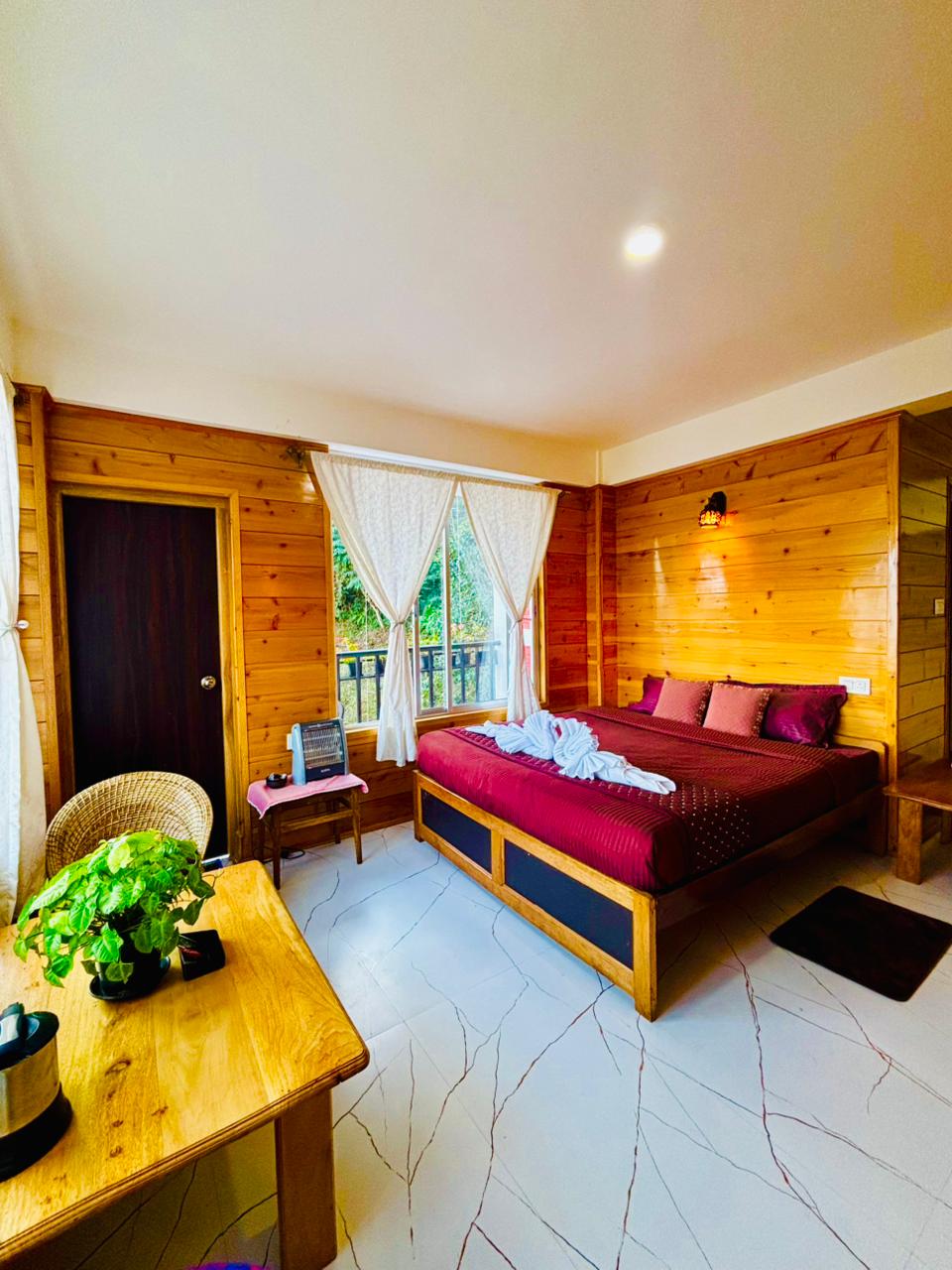 King Suite bedroom with wood panelling, king bed and mountain-facing window