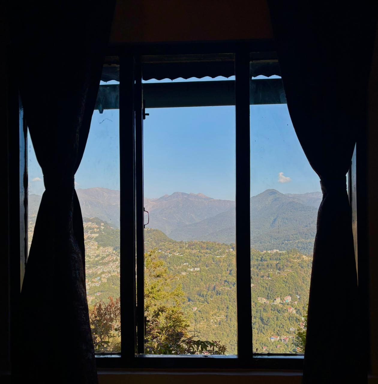 Mountain view framed by a guest room window at Arosia By Mustard Seed
