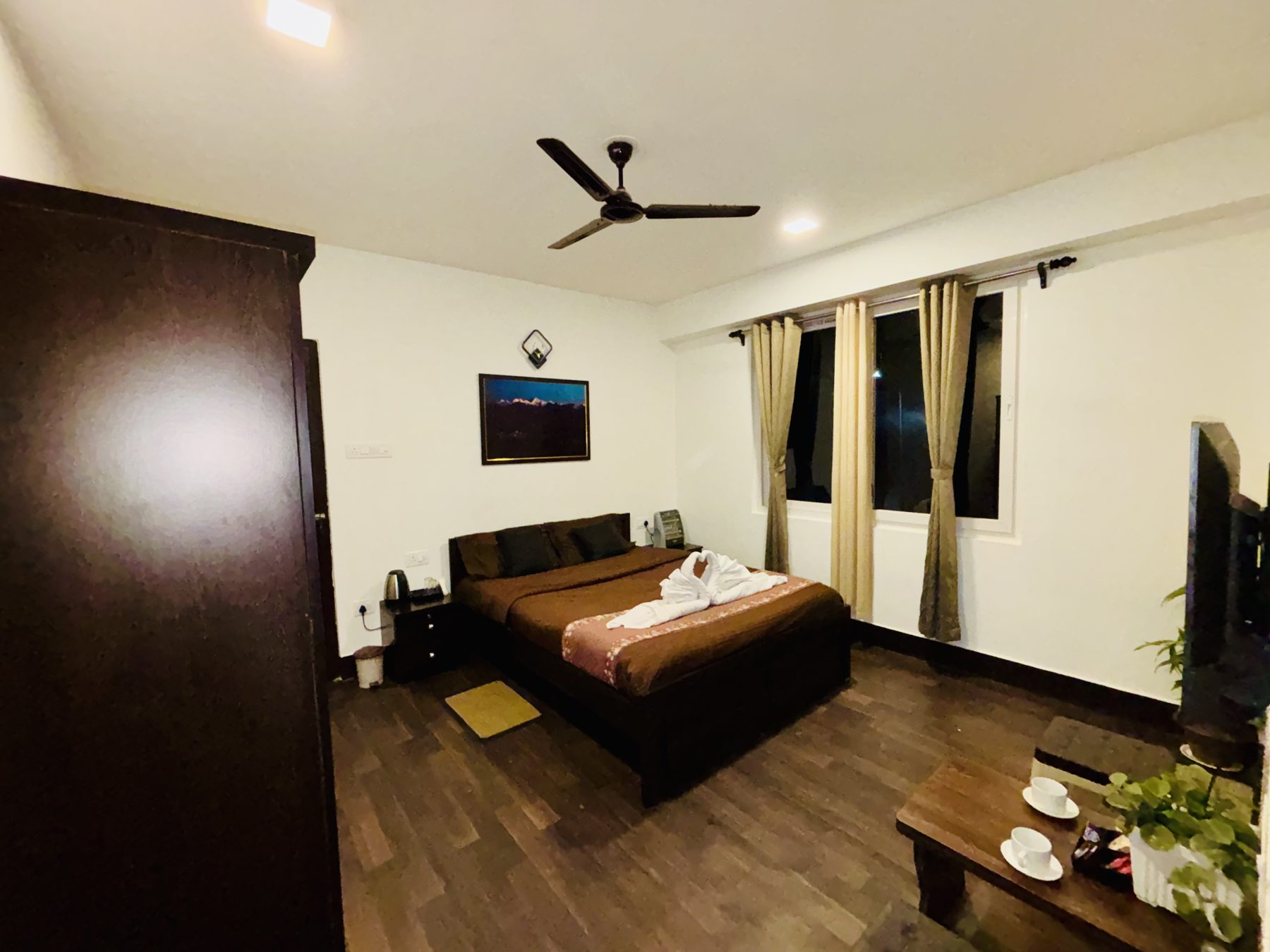 Room interior at Arosia by The Hive with wooden flooring, wardrobe and seating